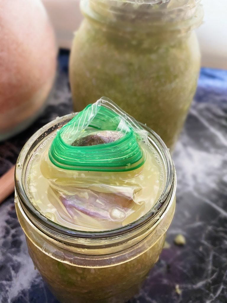 homemade sauerkraut in jar with rock on top