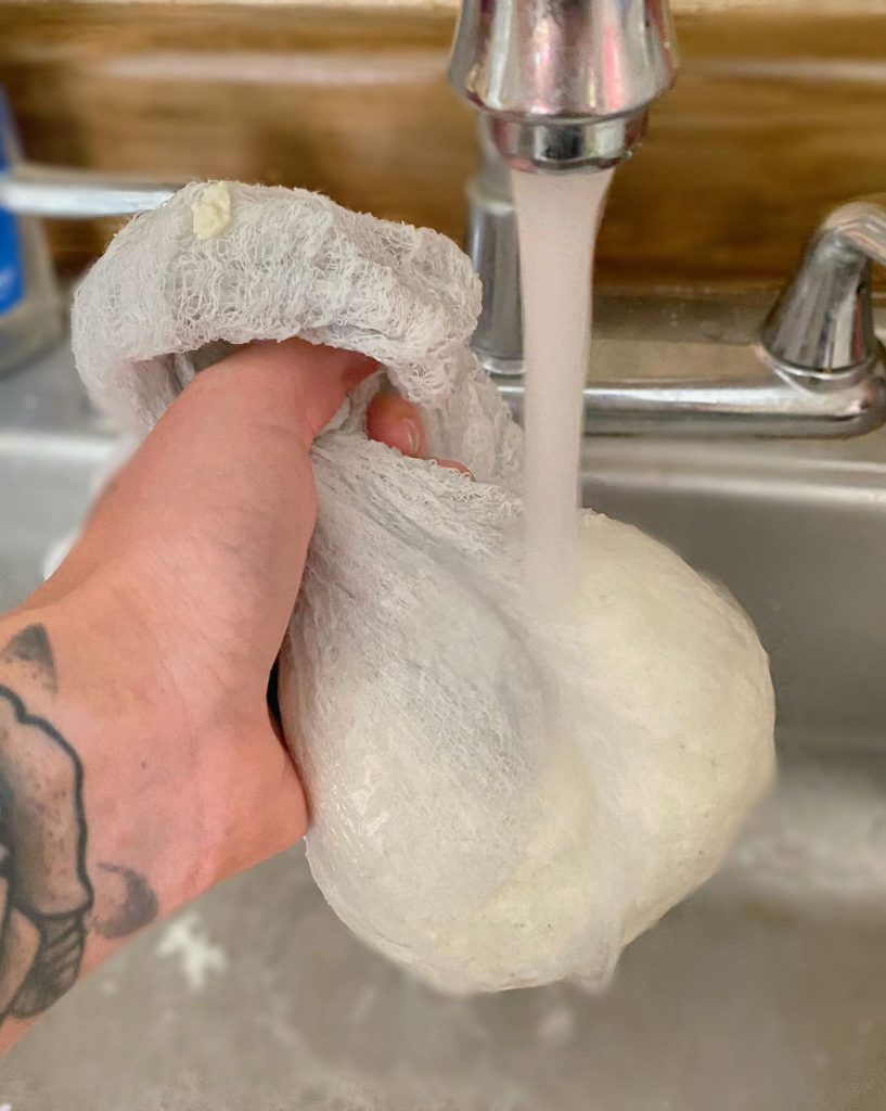 Rinsing cheese ball under cool running water.